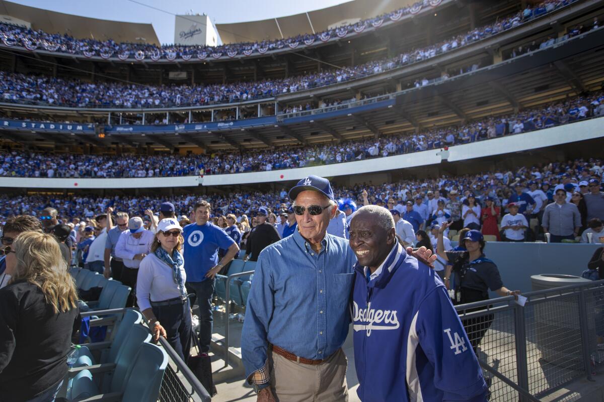 Former Dodgers pitcher Sandy Koufax, left, and former Dodgers outfielder Lou Johnson pose for a photo.