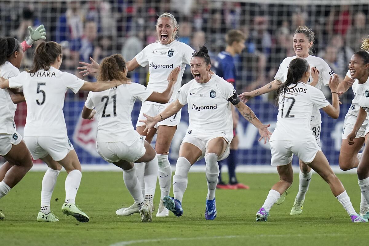 Gotham FC defender Ali Krieger, center with black captain's band, celebrates with her teammates against the OL Reign.