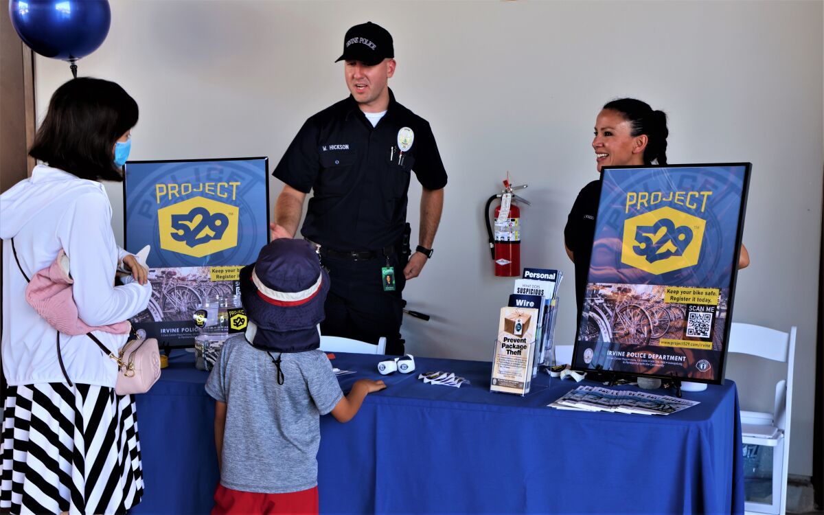 Irvine police officers promote Project 529, an online registry that makes bike recovery easier, at a June 2021 open house.