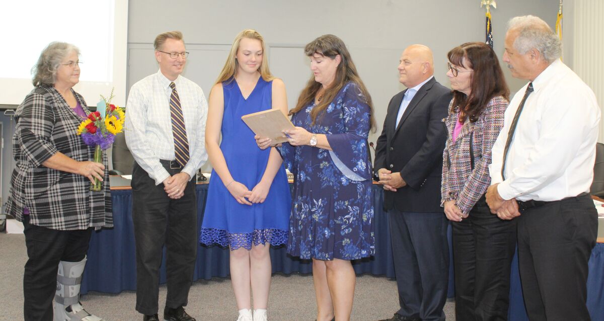 Ramona Unified’s Inspirational Student of the Month, Mountain Valley Academy student Adelaide Sorbo, listens as school board President Dawn Perfect reads the Victor Hugo quote on the plaque Sorbo received. Also pictured are trustees Kim Lasley, Rodger Dohm, Daryn Drum and Bob Stoody and Superintendent Theresa Grace.
