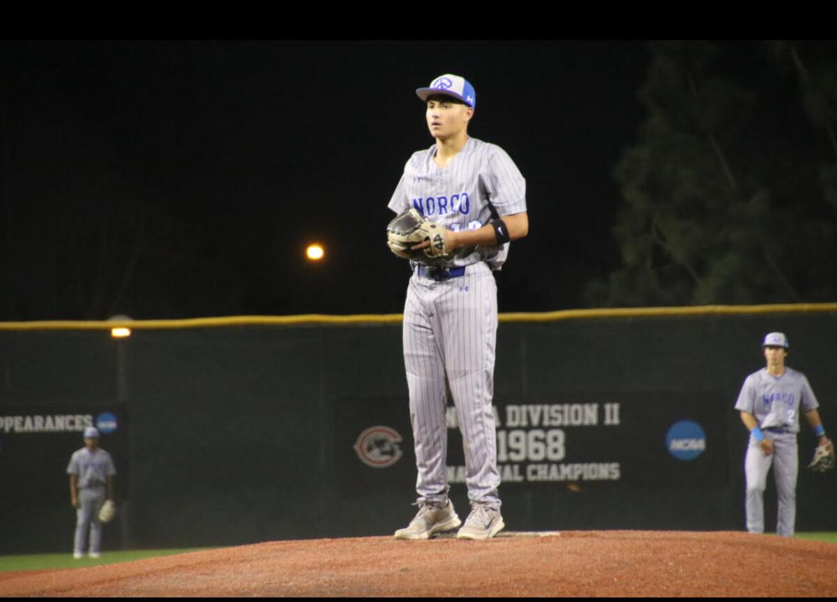 Freshman pitcher Jordan Ayala of Norco takes the sign as he prepares to deliver a pitch.