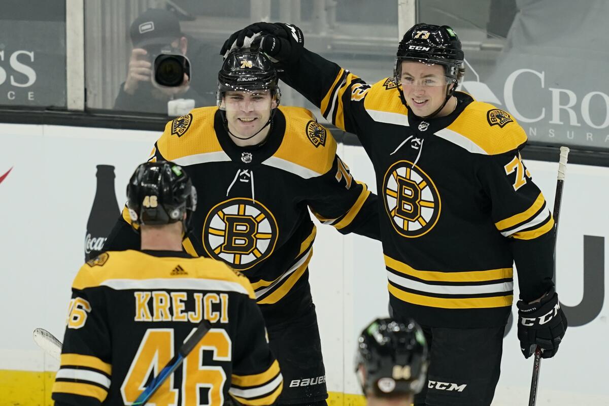 Boston Bruins left wing Jake DeBrusk (74) celebrates his goal with Charlie McAvoy (73) and David Krejci (46) during the second period of the team's NHL hockey game against the New York Rangers, Thursday, March 11, 2021, in Boston. (AP Photo/Elise Amendola)