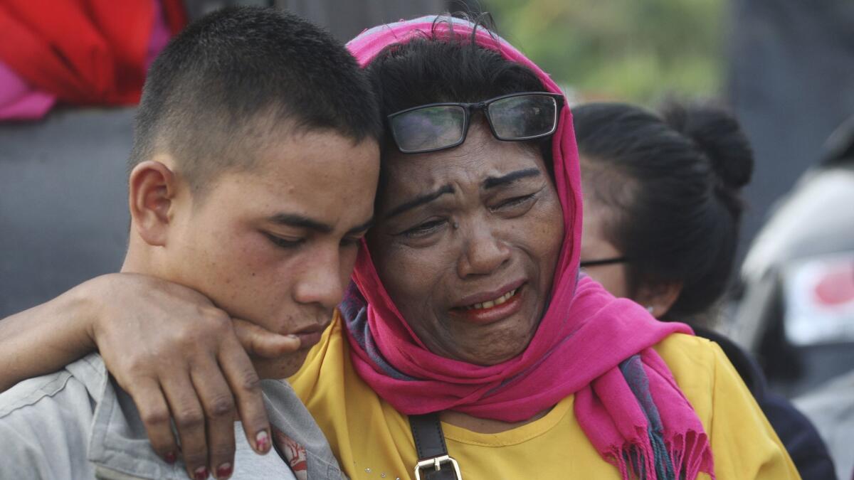 Relatives wait for news at the Tigaras port at Lake Toba, North Sumatra, on Wednesday.