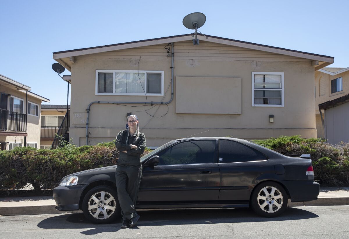 Talena Handley stands in front of her first car, a black 1999 Honda Civic.