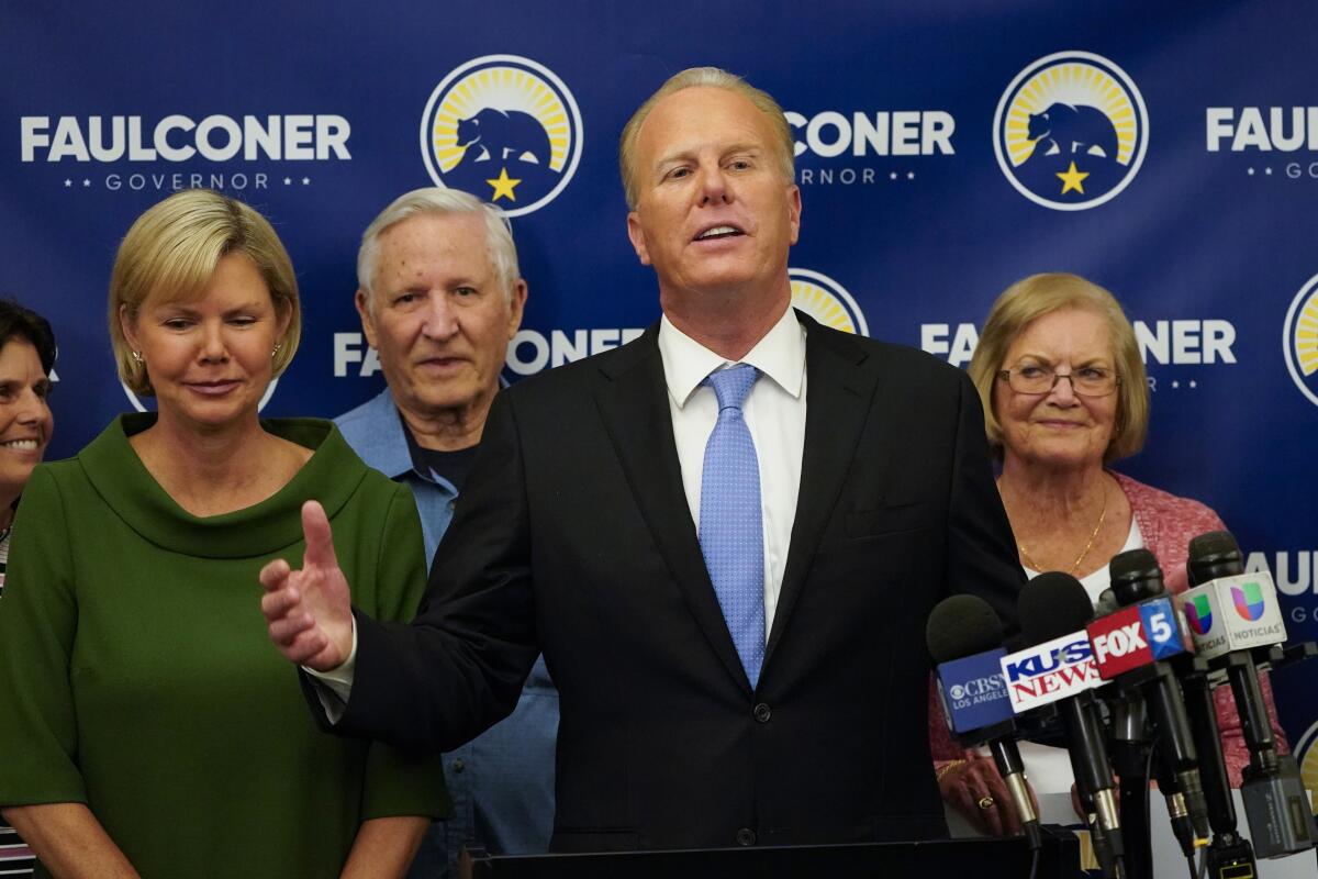 Kevin Faulconer speaks alongside others before a sign that says "FAULCONER - GOVERNOR"