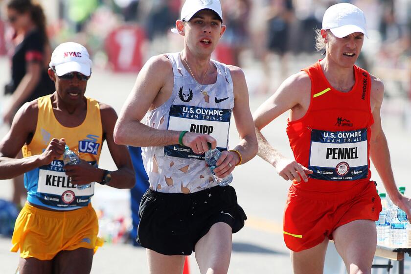 Galen Rupp leads Tyler Pennel and Meb Keflezighi as they pass a water station during the U.S. Olympic men's marathon trials on Saturday.