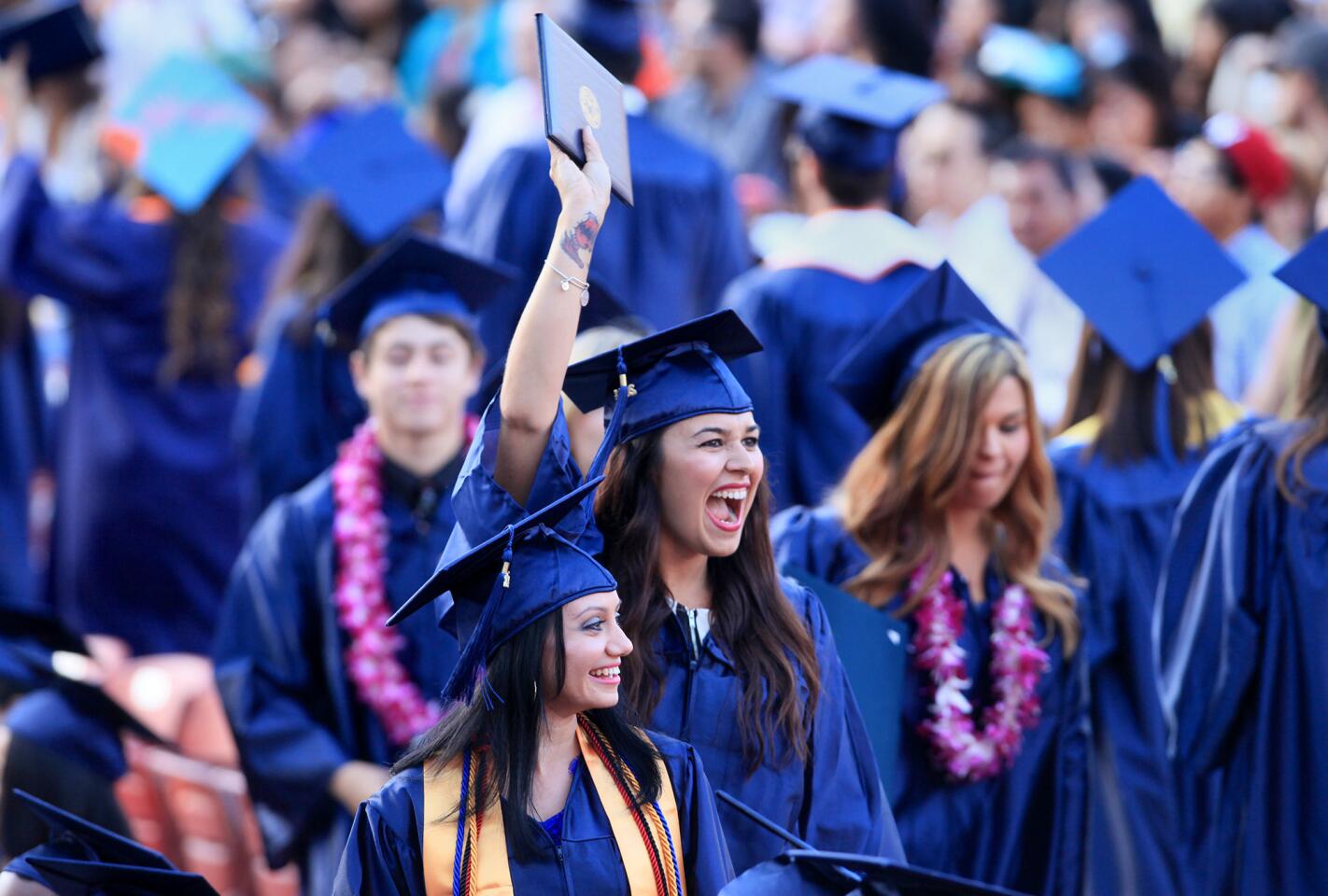 Sheaya Marie Rojas, center, cheers as she waves her diploma in the air during Orange Coast College's 66th Commencement Ceremony on Wednesday at Pacific Amphitheatre in Costa Mesa. Rojas earned her Associates in Science degree by studying Neurodiagnostic Technology. (Kevin Chang/ Daily Pilot)