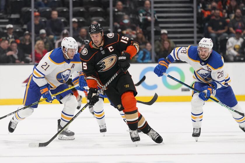Anaheim Ducks' Ryan Getzlaf, center, skates past Buffalo Sabres' Zemgus Girgensons, right, and Kyle Okposo during the second period of an NHL hockey game Thursday, Oct. 28, 2021, in Anaheim, Calif. (AP Photo/Jae C. Hong)