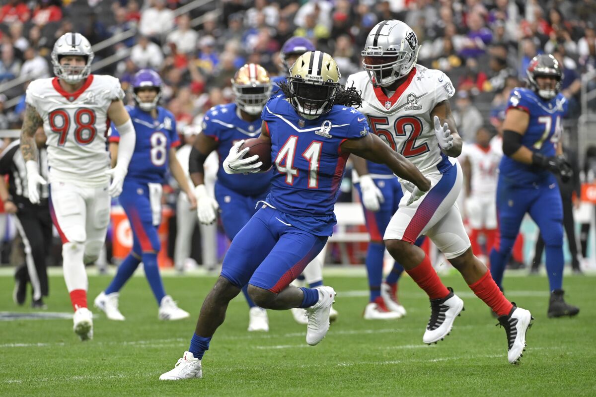 NFC running back Alvin Kamara of the New Orleans Saints (41) rushes as AFC inside linebacker Denzel Perryman of the Las Vegas Raiders (52) closes in during the first half of the Pro Bowl NFL football game, Sunday, Feb. 6, 2022, in Las Vegas. (AP Photo/David Becker)