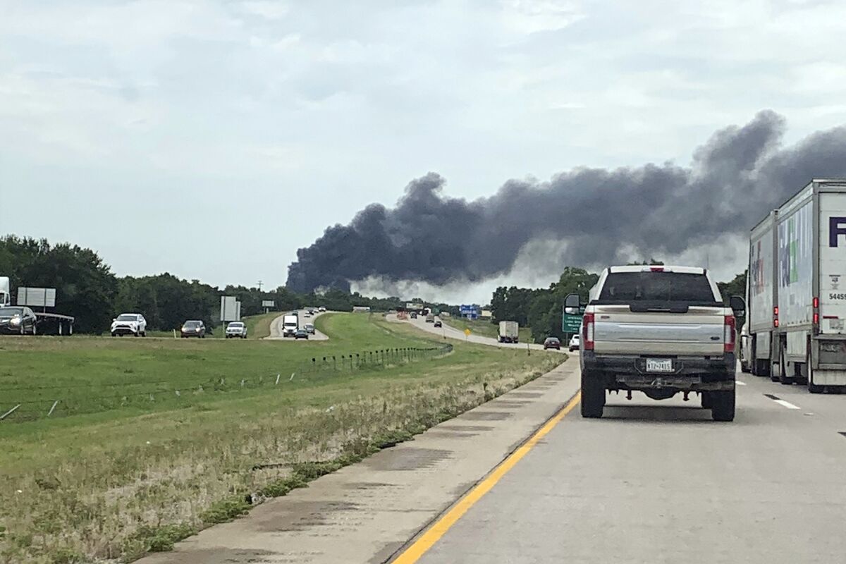 In this image taken from video provided by KXII TV, smoke from an asphalt plant explosion rises in the background, Friday, July 16, 2021, in Ardmore, Okla. One person was killed in the explosion in southern Oklahoma, police said. (Kemper Ball/KXII TV via AP)