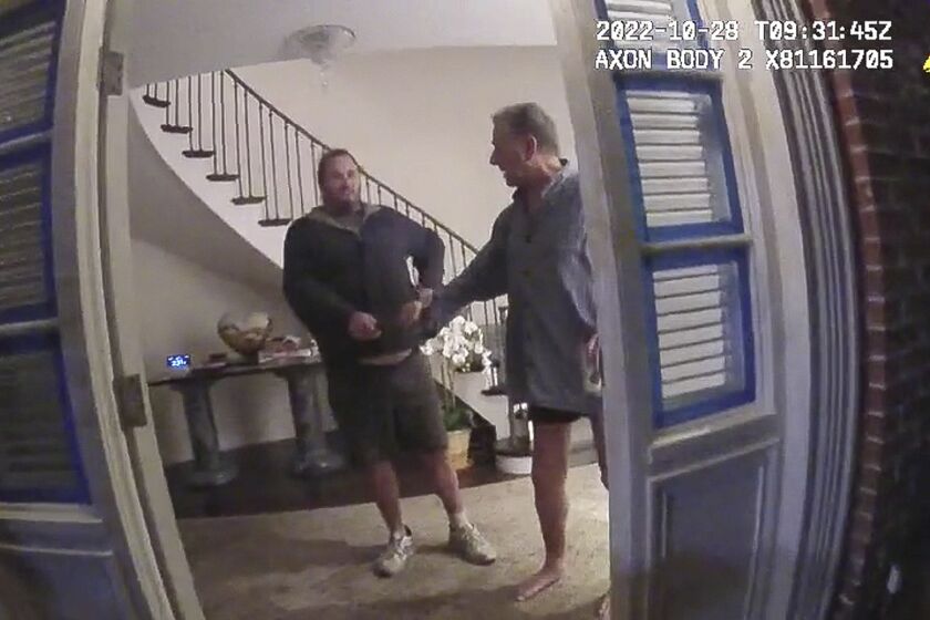 This image from video from police body-worn camera footage, released by the San Francisco Police Department, shows Paul Pelosi, right, fighting for control of a hammer with his assailant, David DePape, during a attack at Pelosi's home in San Francisco on Oct. 28, 2022. DePape wrests the tool from Pelosi and lunges toward him the hammer over his head. The blow to Pelosi occurs out of view of the video as officers rush into the house and subdue DePape. (San Francisco Police Department via AP)