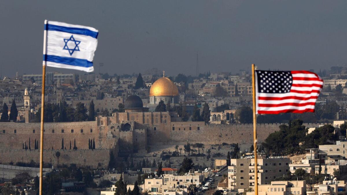 Israeli and U.S. flags fly against the backdrop of the Old City of Jerusalem on Dec. 13.