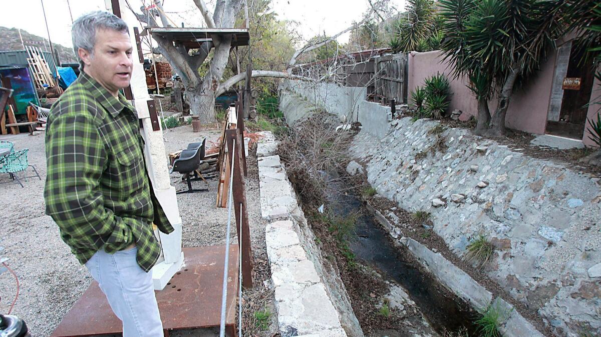 Sculptor Louis Longi, seen here in 2014 looking at Laguna Canyon Creek, has a revised proposal for artist work/live units that the California Coastal Commission will consider Wednesday.
