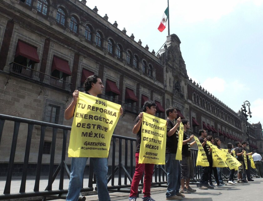 Greenpeace activists outside the National Palace in Mexico City hold banners denouncing the energy overhaul supported by Mexican President Enrique Peña Nieto: "EPN: Your energy reform destroys Mexico."