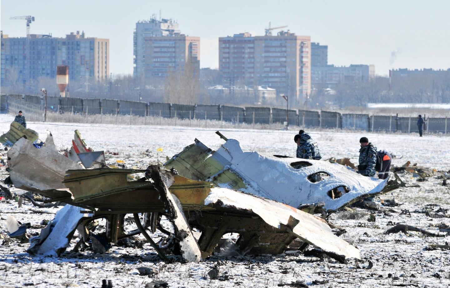 Russian investigators and policemen collect remains of bodies and inspect a site of the crash of Boeing 737-800 of FlyDubai airliner at the airport of Rostov-on-Don, Russia, on March 20, 2016. Sixty two people (55 passengers and 7 crew members) died in the crash. The Boeing 737-800 crashed in the second approach of landing in very bad weather conditions.