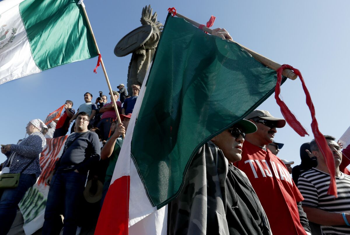 Hundreds of Tijuana residents demonstrate at a rally Nov. 18 at the Cuauhtemoc monument in downtown Tijuana, demanding an end to the Central American immigrant groups passing through Mexico.