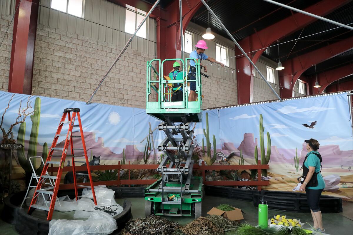 Fair workers on Tuesday design a desert scene for a National Parks theme activity that will be part of the 2021 O.C. Fair.