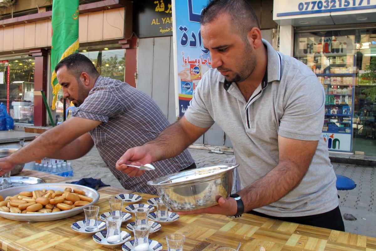 Marwan Naweel, left, and his brother Safwan Naweel prepare tea and biscuits for Shiite Muslim pilgrims in Baghdad on Sunday, the first day of a 10-day Shiite period of mourning.