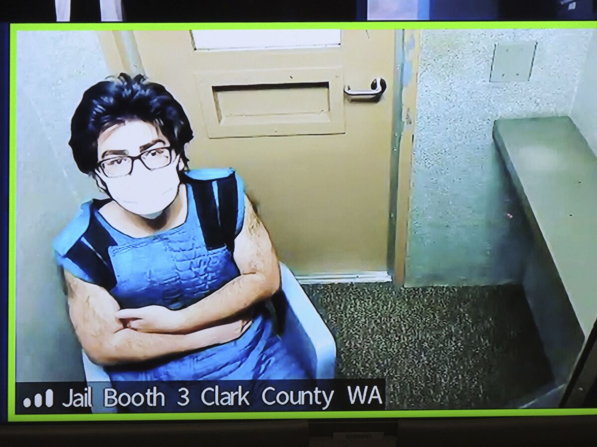 In this photo of a video monitor, Julio Cesar Segura appears remotely in Clark County Superior Court in Vancouver, Wash., on Monday, Jan. 31, 2022, in connection with a Jan. 29, 2022, police pursuit that ended with the mistaken shooting of an off-duty Vancouver Police Department Officer by a deputy from the Clark County Sheriff's Office near Battle Ground, Wash. (The Columbian via AP)
