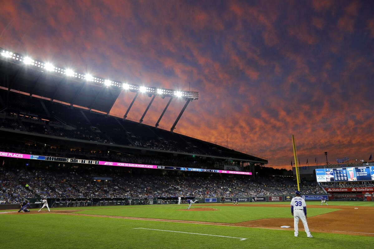 The Texas Rangers play the Kansas City Royals at Kauffman Stadium as a sunset lights up the sky June 27, 2022. 
