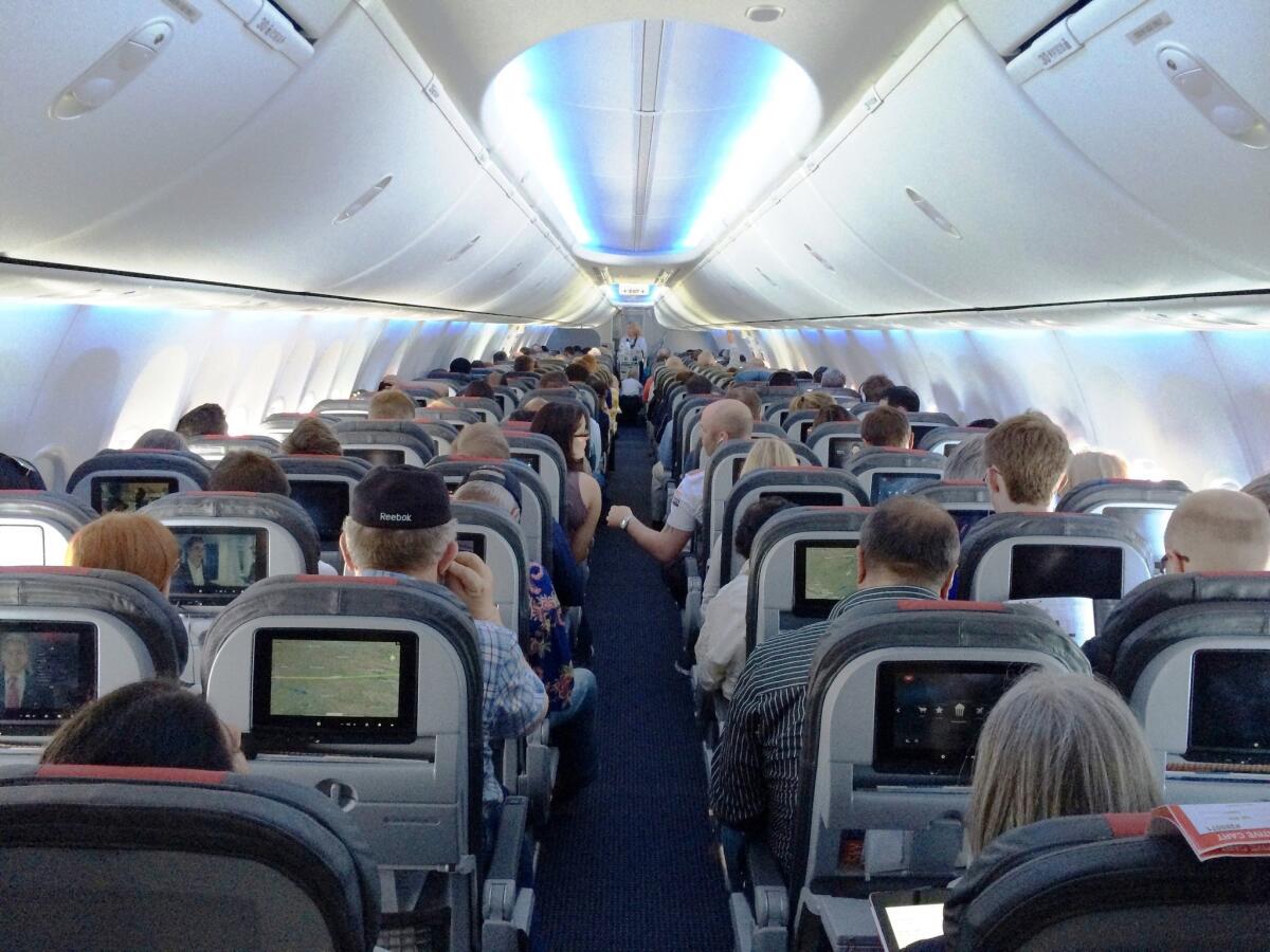 The cabin of this new American Airlines 737 gives standard economy passengers less space, but also an entertainment system to distract them.