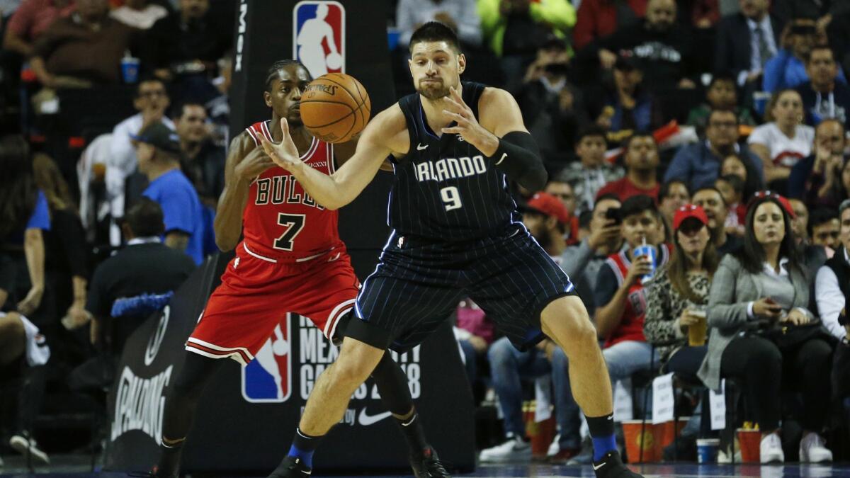 Orlando Magic's Nikola Vucevic, right, is defended by Chicago Bulls' Justin Holiday in the first half.