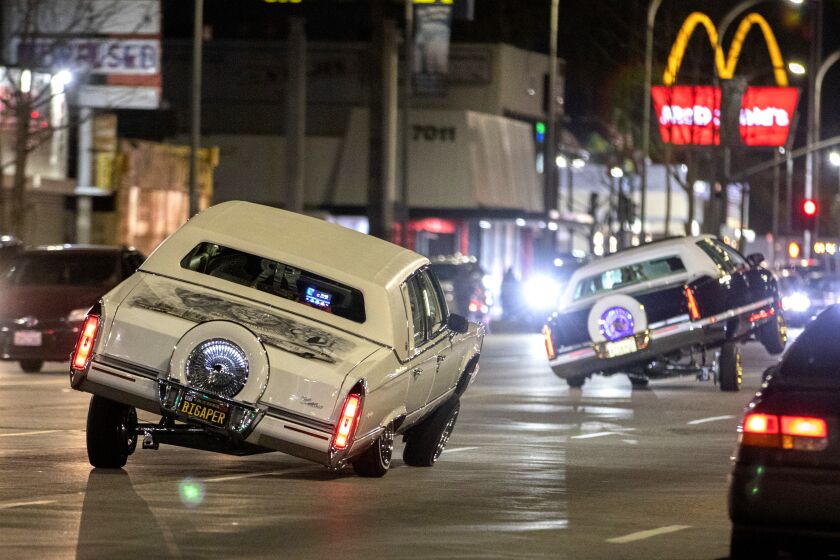 Low riders show off their capabilities while cruising Van Nuys Boulevard