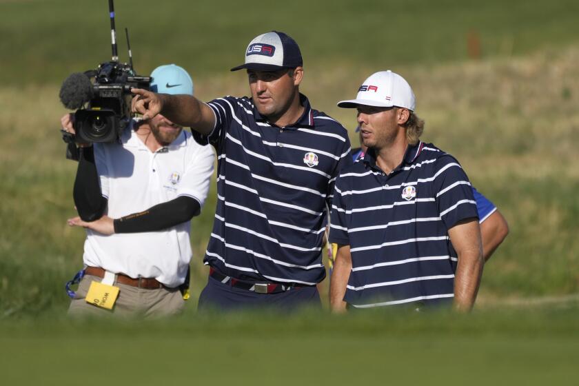 United States' Scottie Scheffler, left gestures with playing partner United States' Sam Burns during their morning Foursome match on the 11th green at the Ryder Cup golf tournament at the Marco Simone Golf Club in Guidonia Montecelio, Italy, Friday, Sept. 29, 2023. (AP Photo/Alessandra Tarantino)