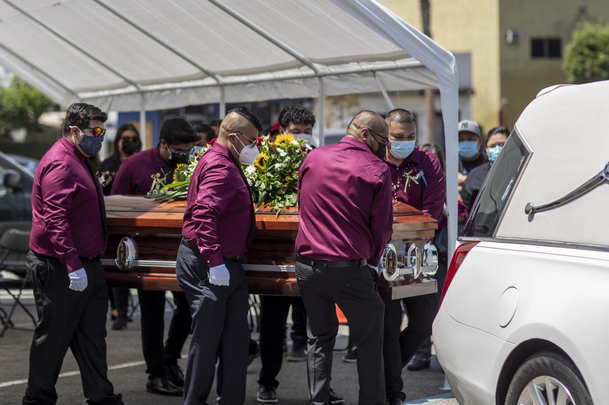 The casket of Felipe Juarez is loaded onto a hearse.