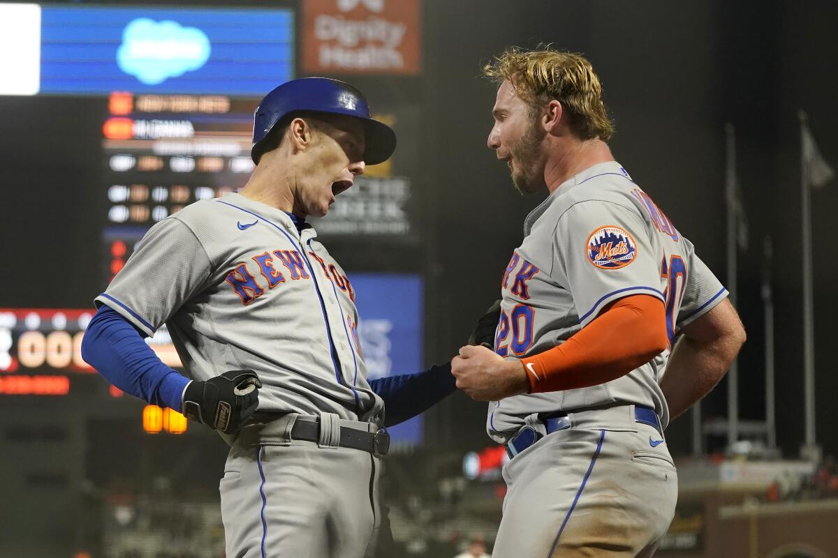 El jugador de los Mets de Nueva York Mark Canha, a la izquierda, es felicitado por Pete Alonso 
