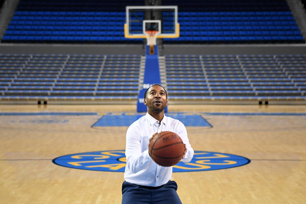 UCLA athletic director Martin Jarmond prepares to shoot a basketball.