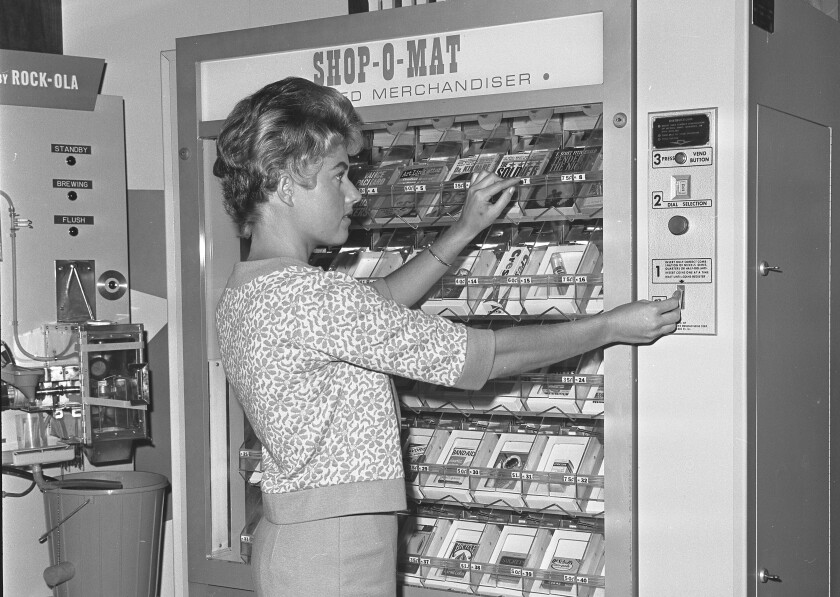 A woman uses a vending machine.