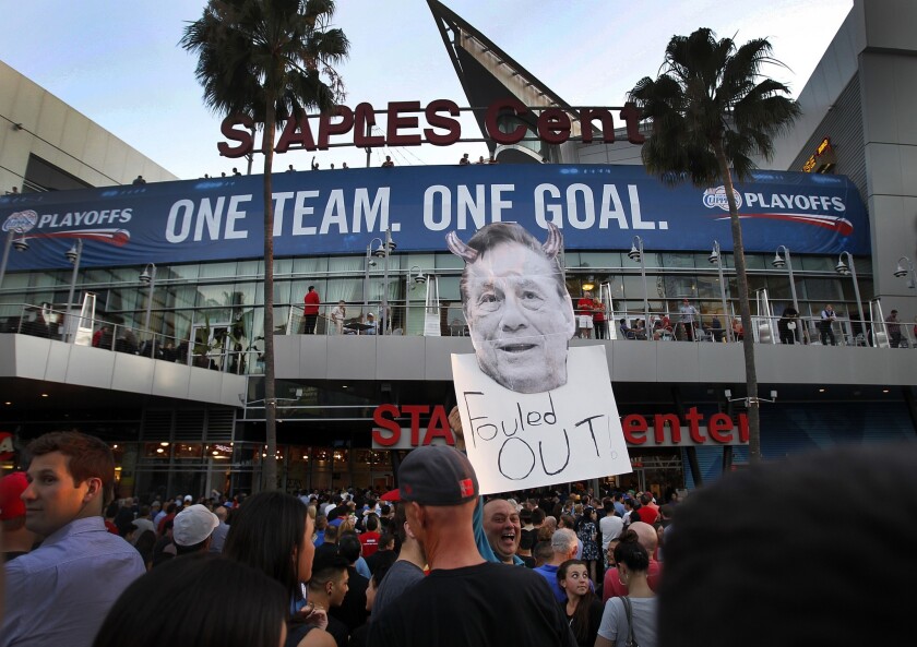 Longtime Clippers fan Abe Dilanian holds a sign in protest of Clippers owner Donald Sterling as he enters Staples Center before the start of Game 5 of the Western Conference quarterfinals against the Golden State Warriors.