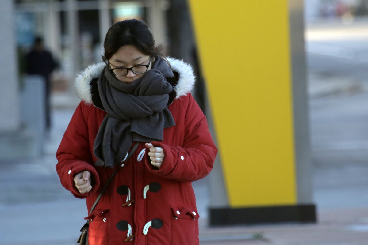 Kimberly Lee is wrapped in warm clothing on her way to a Metro Gold Line station on a very chilly Tuesday morning in Pasadena.