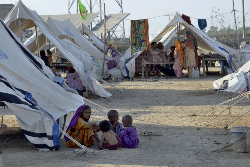 Children play outside their tent at a relief camp, in Jaffarabad, a district in the southwestern Baluchistan province, Pakistan, Thursday, Sept. 29, 2022. Almost 3 million children in Pakistan may miss at least one semester because of flood damage to schools, officials said Thursday, following heavy monsoon rains likely worsened by climate change. (AP Photo/Zahid Hussain)