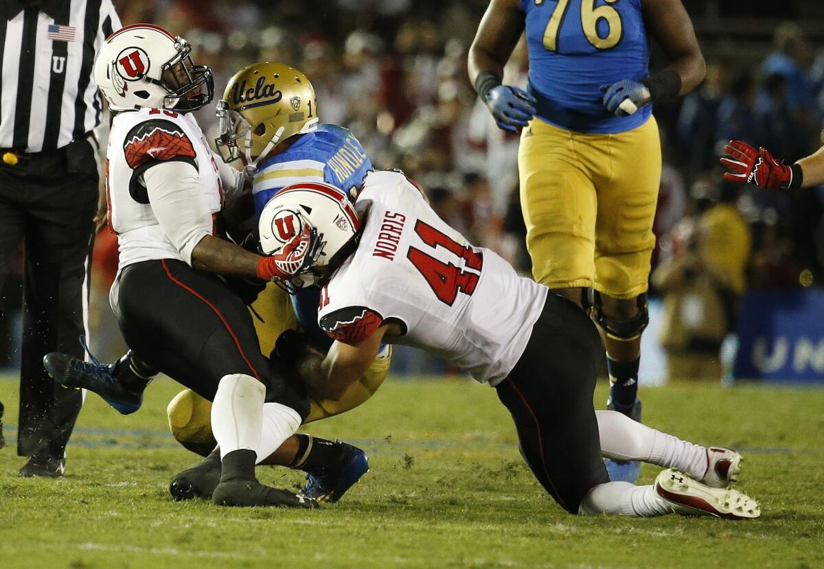 UCLA quarterback Brett Hundley is brought down by Utah's Gionni Paul, left, and Jared Norris. Hundley was sacked 10 times by the Utes during the Bruins' 30-28 loss.