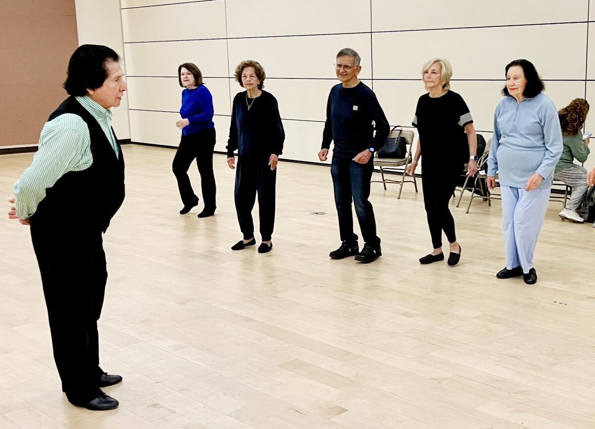 A line of older people taking a dance class