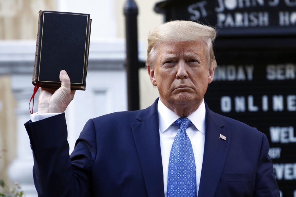 A man holding a Bible in front of a church sign 