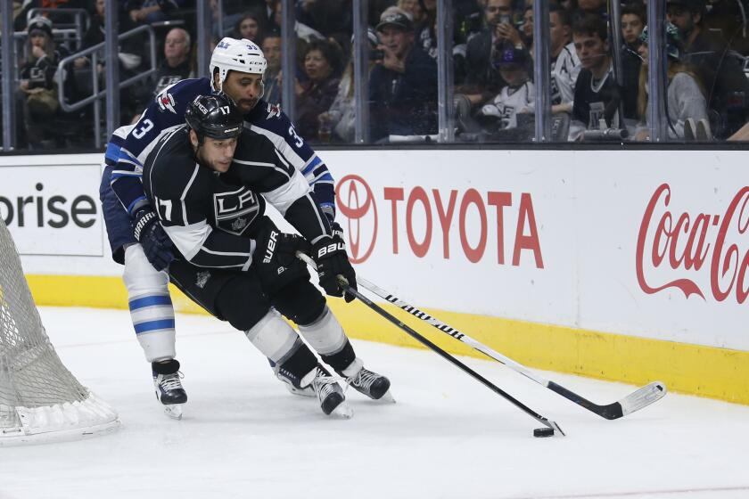 Kings forward Milan Lucic skates with the puck while Jets defenseman Dustin Byfuglien defends him during the second period of a game on April 9.