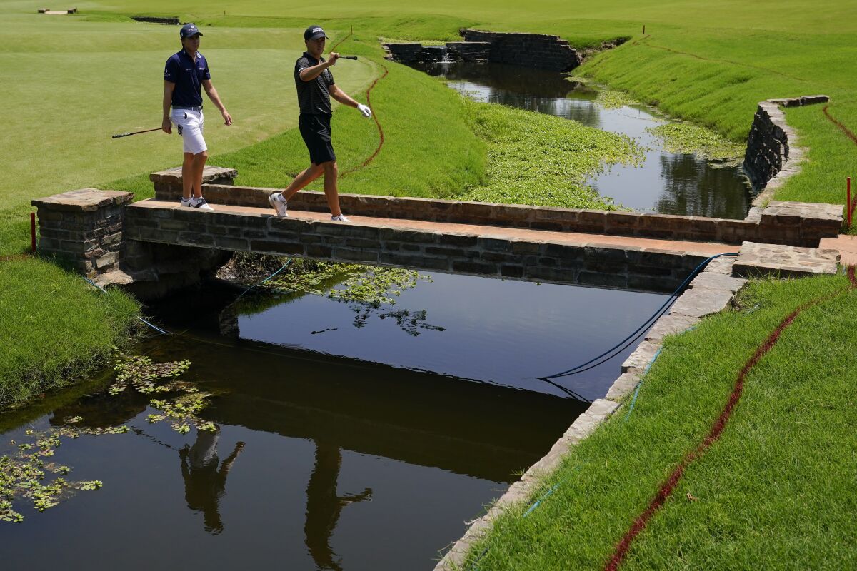Carlos Ortiz, of Mexico, and Jordan Spieth walk on the third hole during a practice round for the PGA Championship golf tournament, Wednesday, May 18, 2022, in Tulsa, Okla. (AP Photo/Matt York)