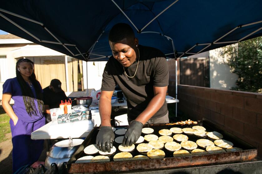 Compton, CA., February 25, 2020 - Dion Steward Jr., 24, of Compton, founder of Munchie Madness, cooks for his customers on Tuesday, February 25, 2020 in Compton, California. It's Taco Tuesday and Steward uses social media like Facebook and Instagram to market and sell his food.(Jason Armond / Los Angeles Times)