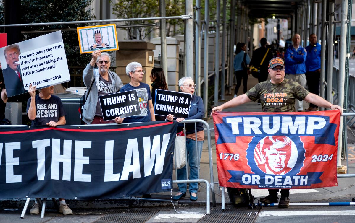 Protesters gather before former President Trump arrives for a deposition in New York in April.