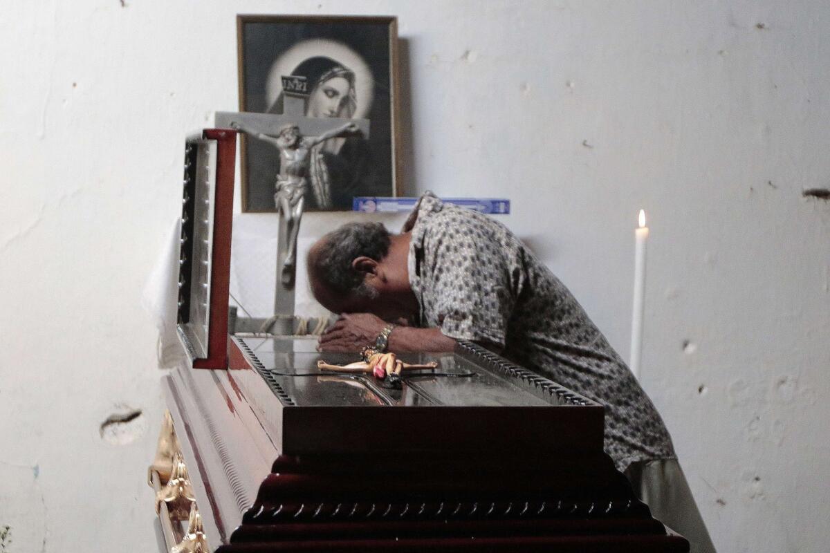 A man attends the wake of Miguel Angel Jimenez Blanco in Xaltianguis, Mexico, on Sunday. Jimenez led a civilian group that has been searching the hills of Mexico's Guerrero state for the bodies of 43 missing students.