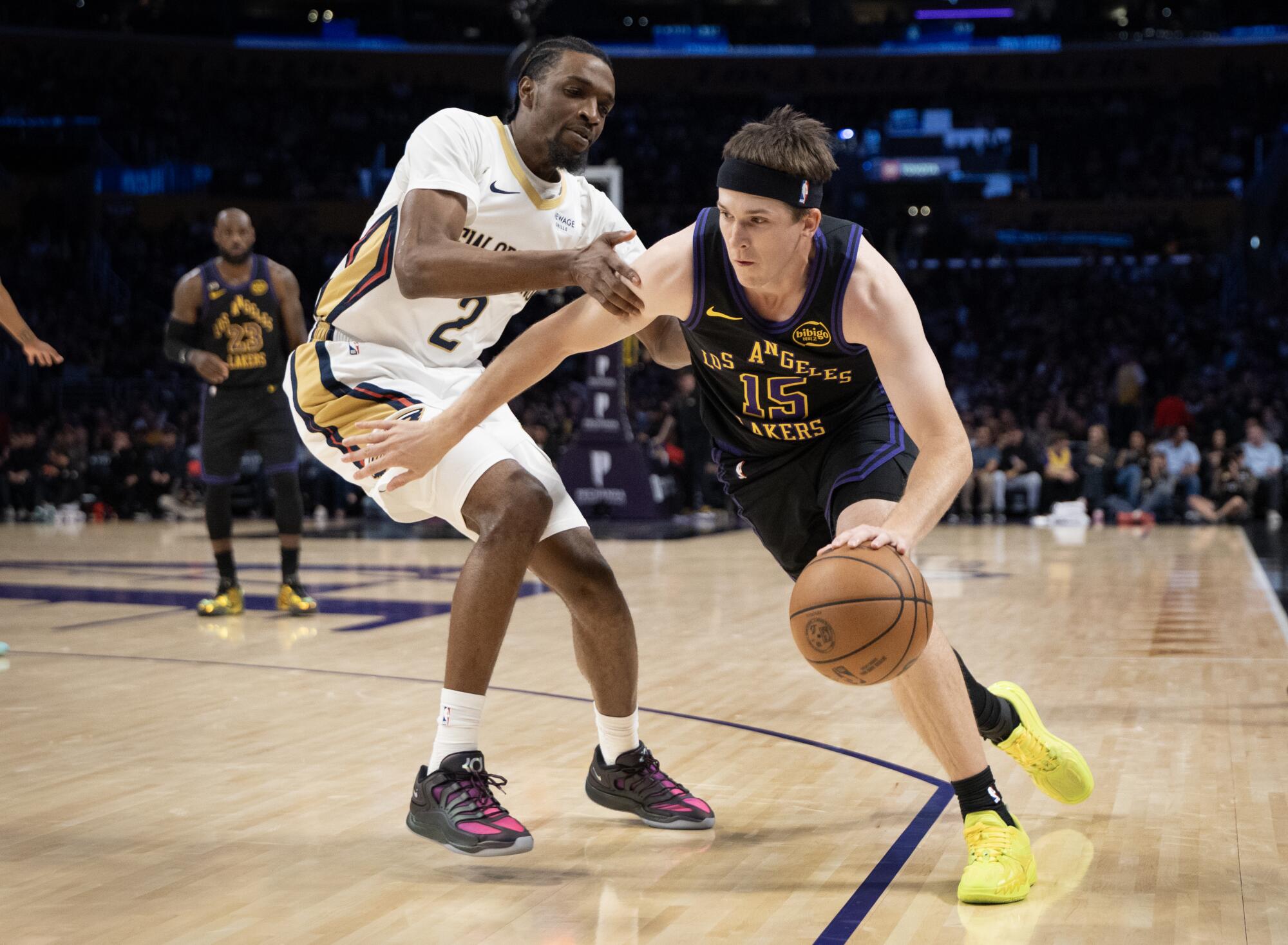 Lakers guardı Austin Reaves, Salı günü Crypto.com Arena'da Pelicans forveti Herbert Jones'un etrafında top sürüyor.