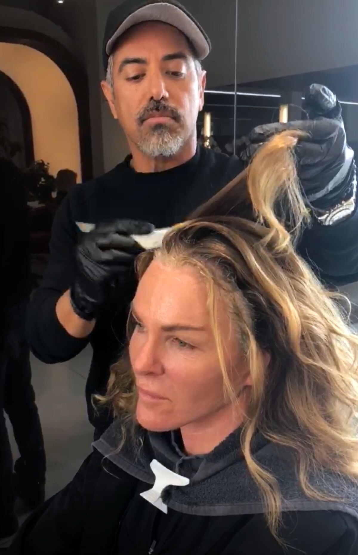 Before the coronavirus lockdown, hair colorist Dani Hernandez works with a client at the Dani H at Sally Hershberger LA salon.