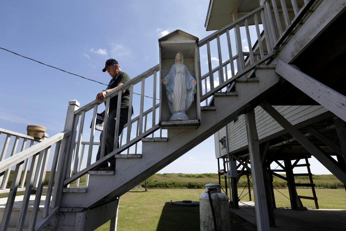 Chief Albert Naquin visits some of the homebound residents who still live on the Isle of Jean Charles, where he administers Catholic communion to them. (Carolyn Cole / Los Angeles Times)