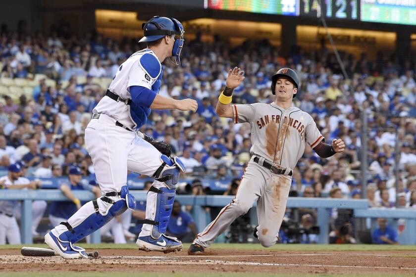 San Francisco Giants' Evan Longoria, right, scores after Kevin Pillar grounded out as Dodgers catcher Will Smith stands at the plate during the first inning of a baseball game Saturday, Sept. 7, 2019, in Los Angeles. (AP Photo/Mark J. Terrill)