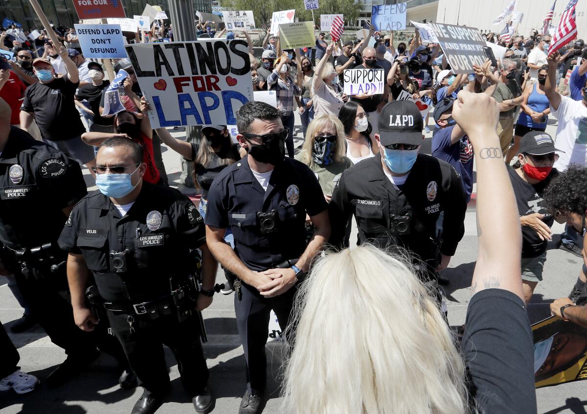 LAPD officers form a line to separate pro- and anti-police demonstrators outside LAPD headquarters in downtown Los Angeles
