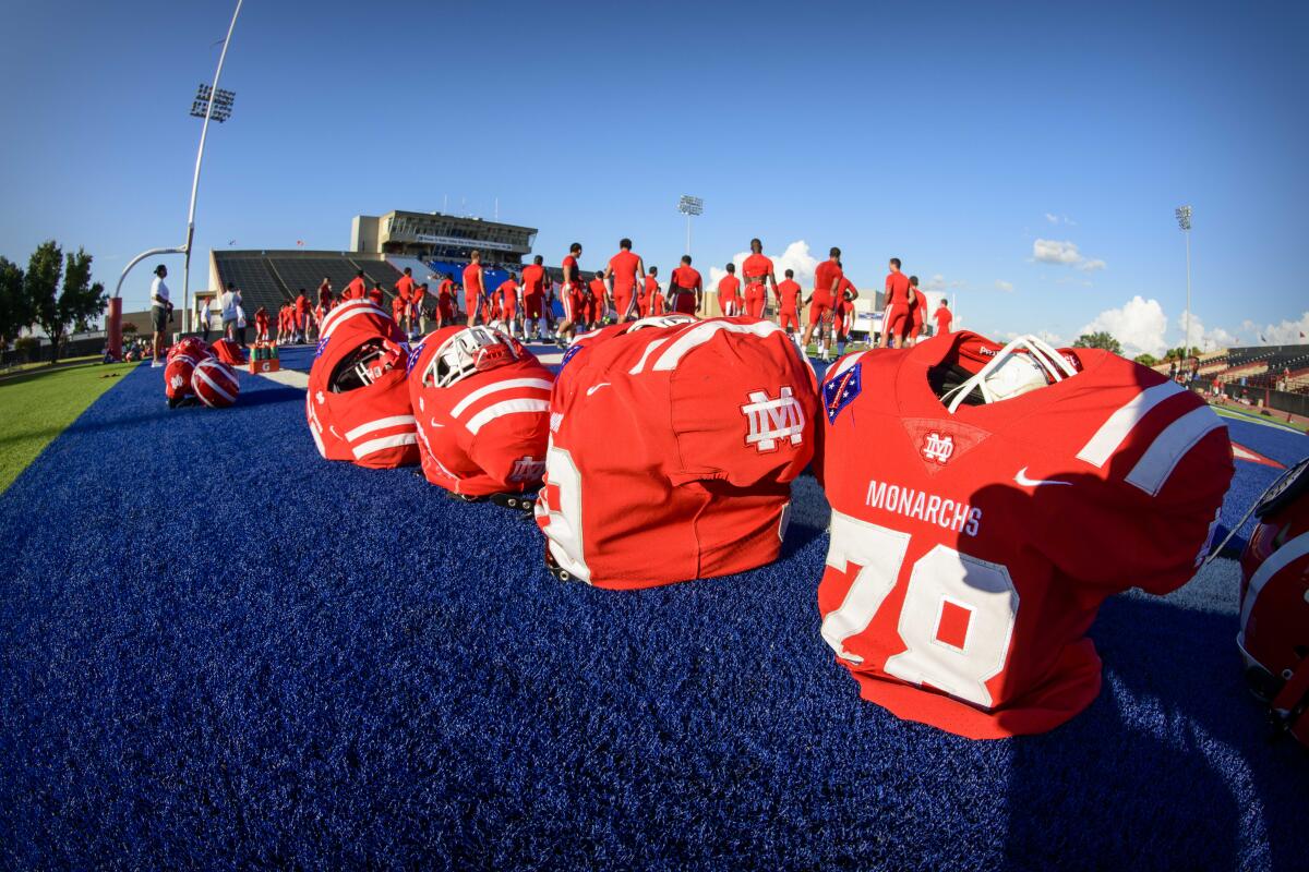 A row of football jersey alongside a football field.