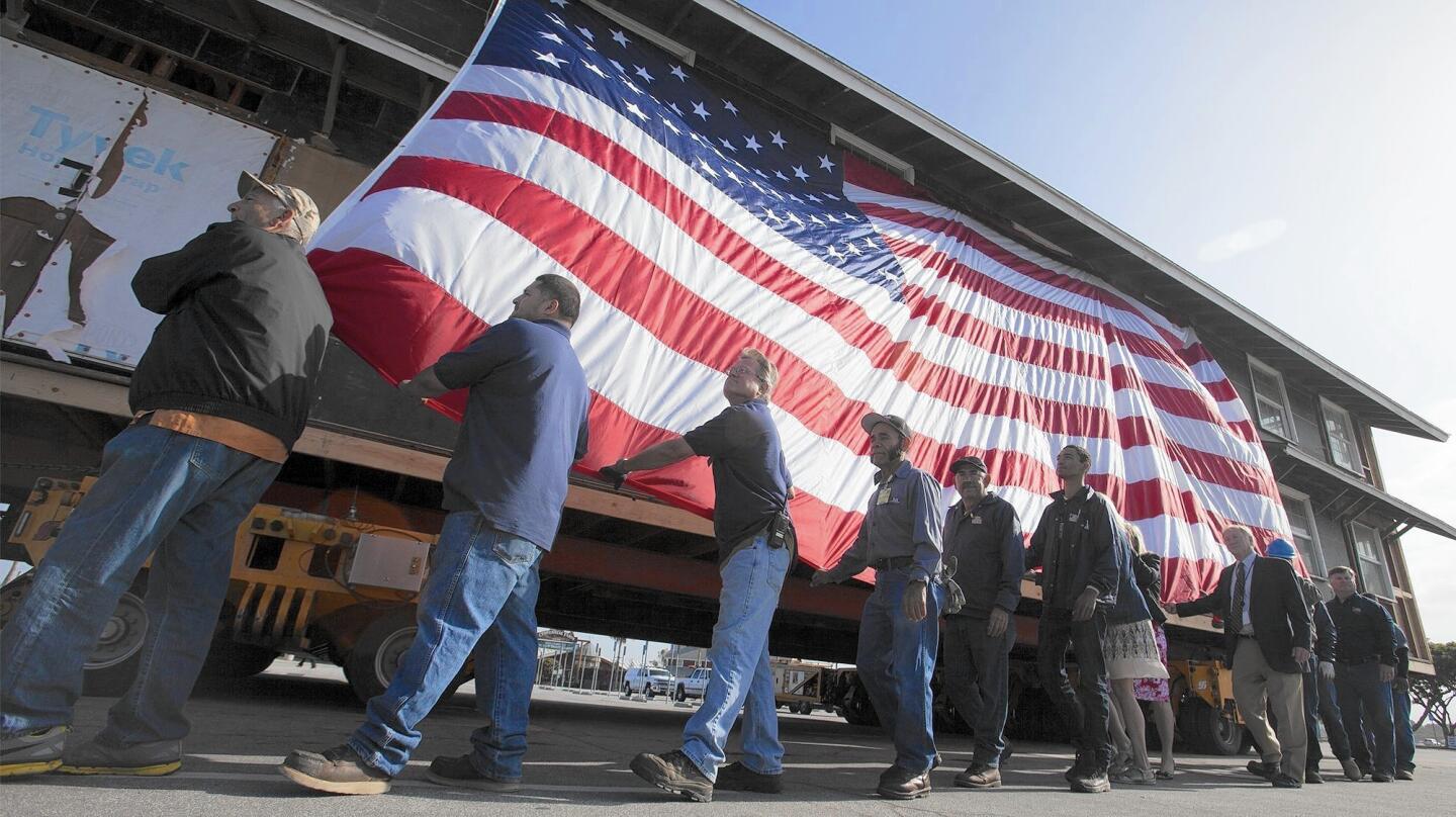 Crew members move Heroes Hall to its permanent location at the Orange County Fairgrounds in Costa Mesa on Monday. It will become a veterans museum that is scheduled to open Nov. 11, Veterans Day.